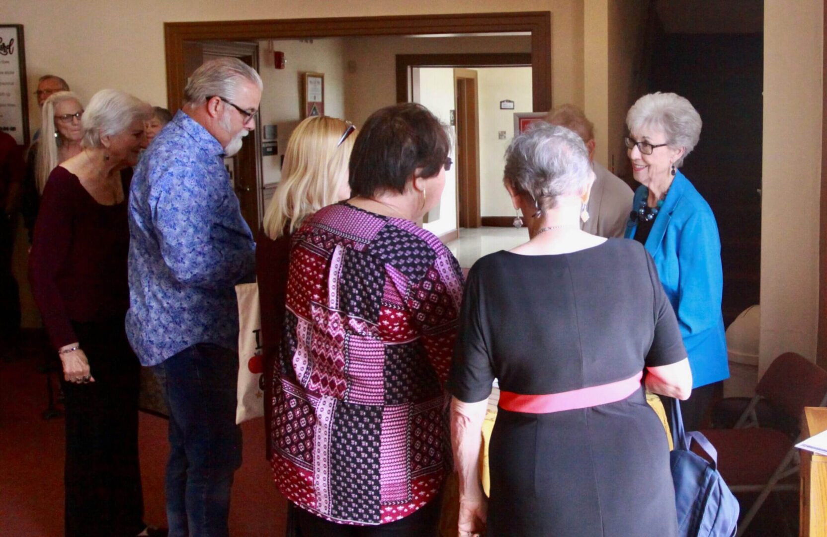 A group of older people standing in a room.